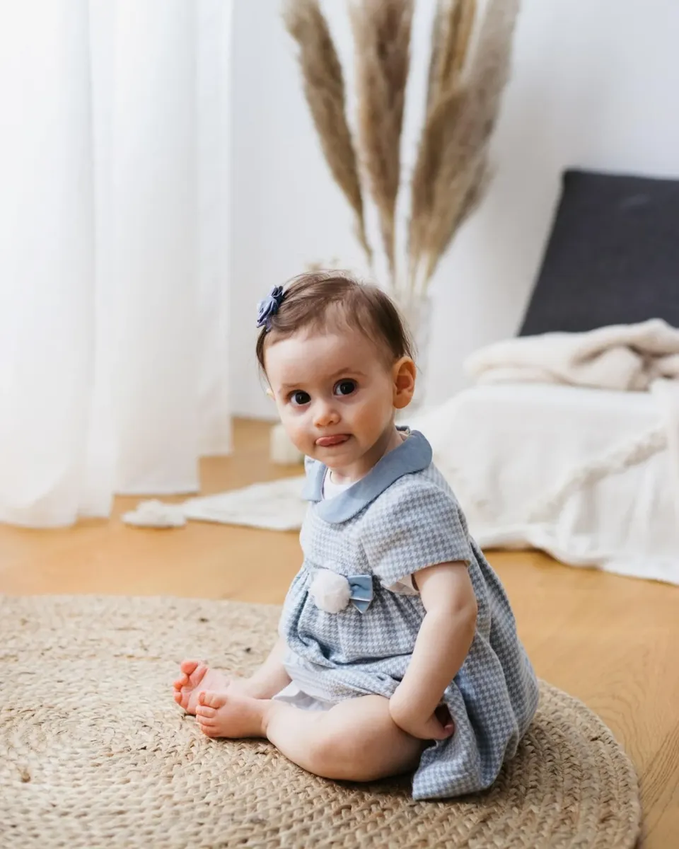 Bimba seduta con vestitino azzurro in studio fotografico bebe Milano