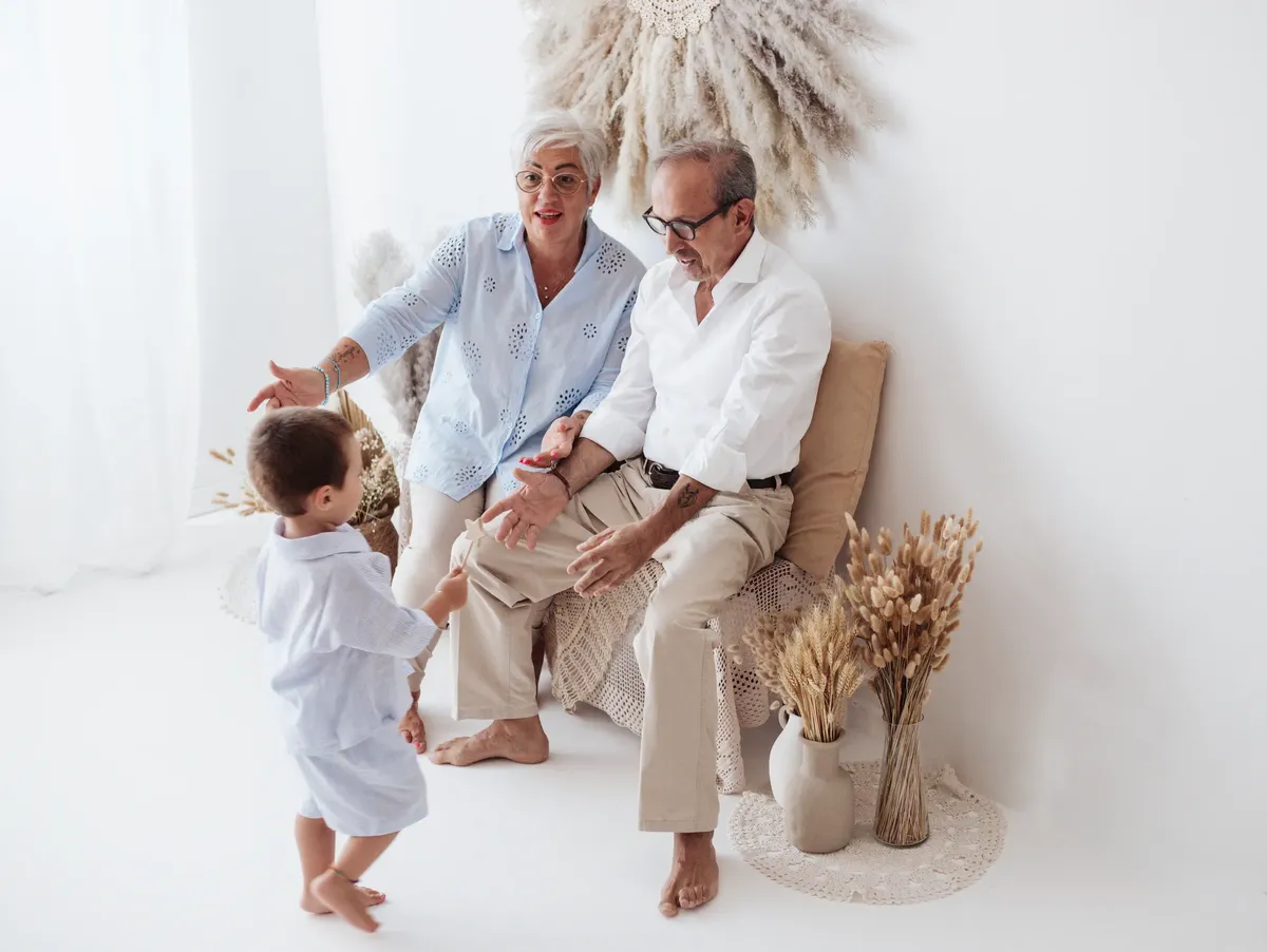 Nonni che accolgono nipotino in studio con decorazioni boho, fotografia famiglia Milano